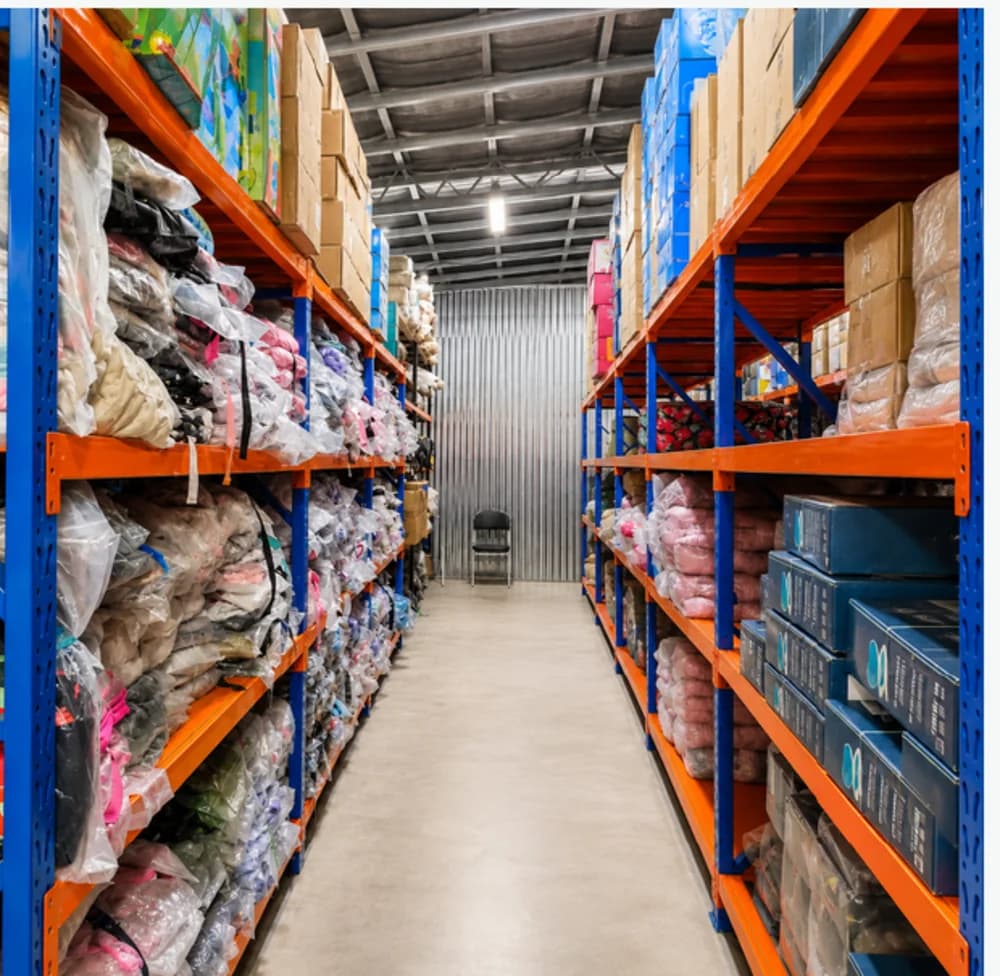Bagged and boxed goods on orange racking in a Brotherhood Group distribution warehouse